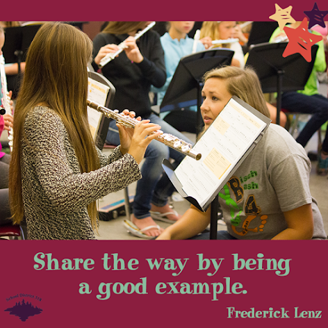 Image of high school student helping middle school student Image of high school student helping middle school student